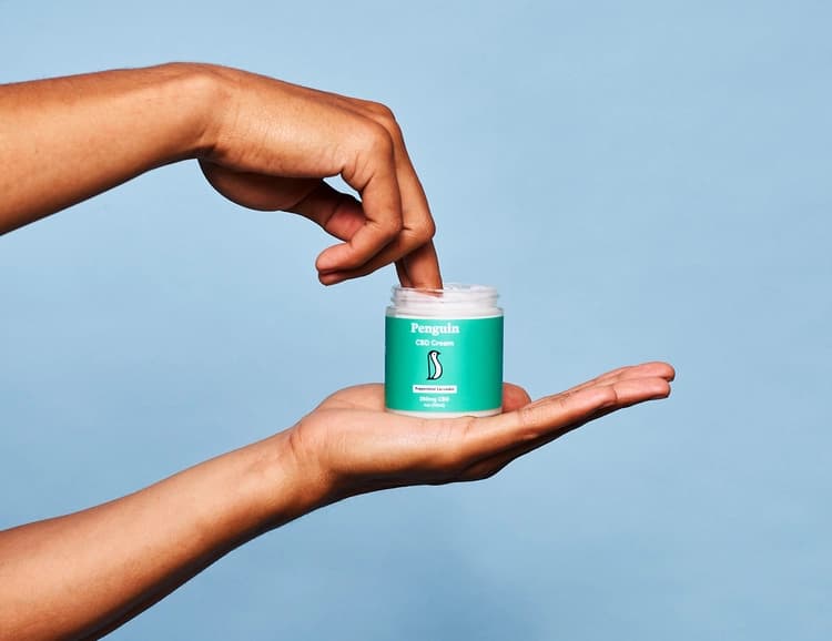 hand getting cbd cream from jar